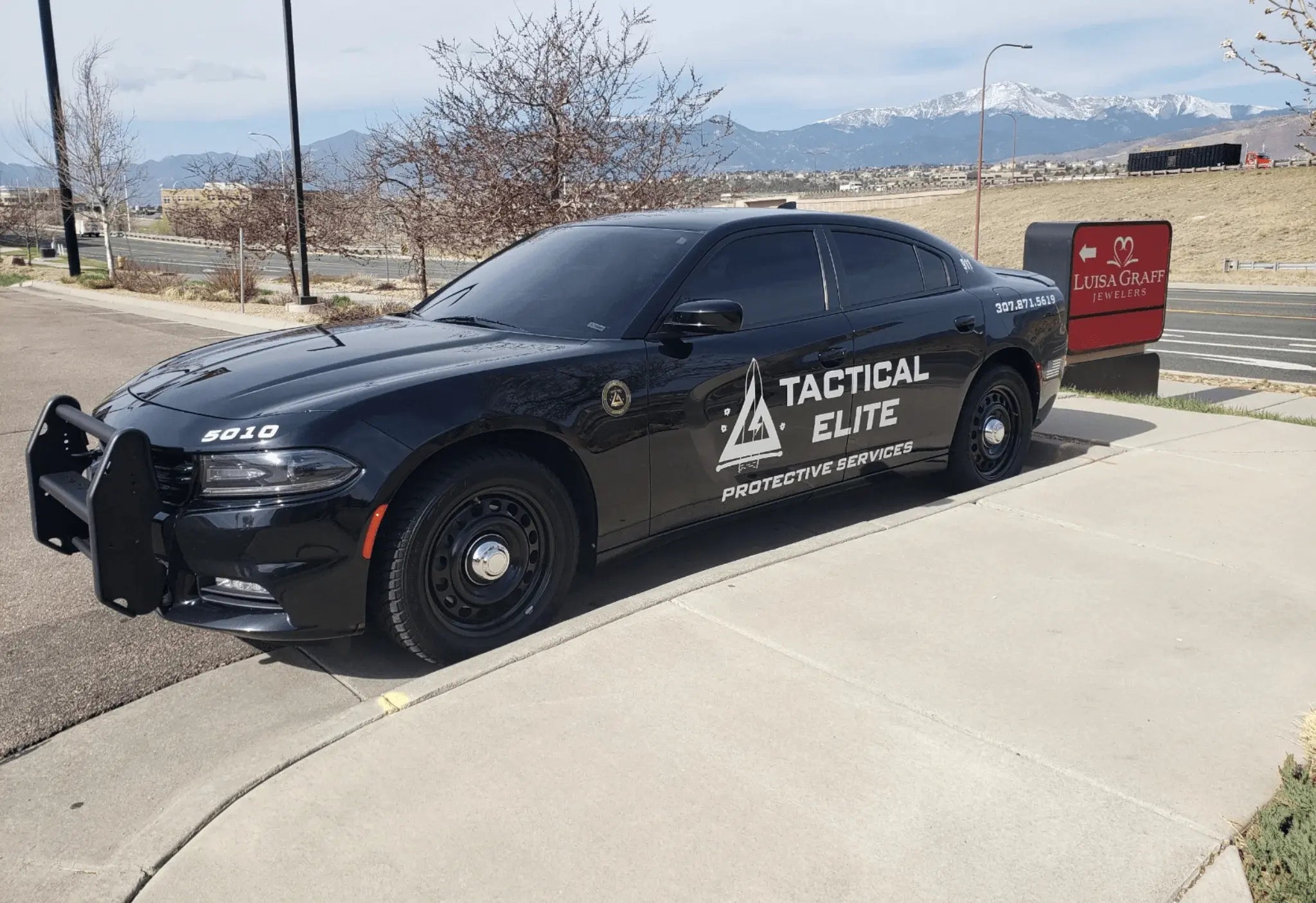 Security personnel assisting with emergency flood response, moving a boat through high water during a rescue operation.